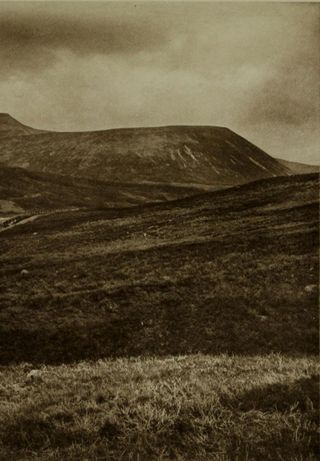Schwarz-weiß Aufnahme einer kargen hügeligen Landschaft. Der Himmel ist wolkenverhangen. Das Bild straht eine tiefgehende Tristesse aus.